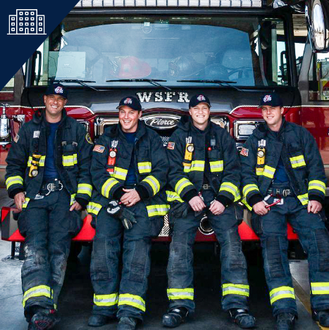 Firefighters in front of a fire truck in a fire station