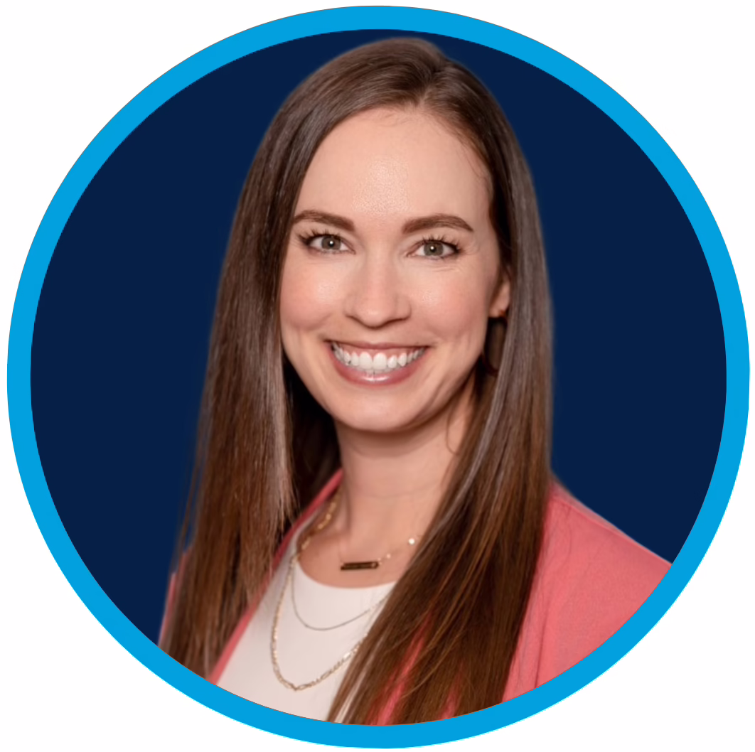 Portrait of a smiling woman with long brown hair, wearing a coral blazer over a white top, set against a dark blue background with a bright blue circular border.